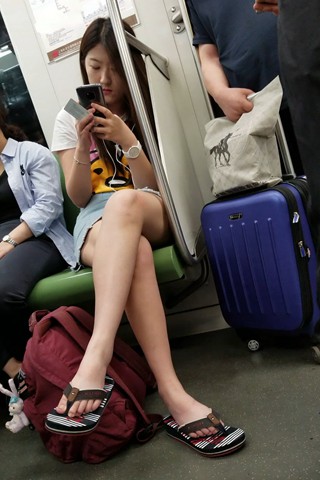 地铁上依靠着扶手玩手机的牛仔裙姑娘