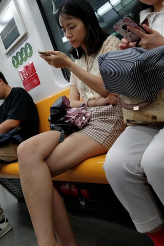 地铁上看手机的小姑娘